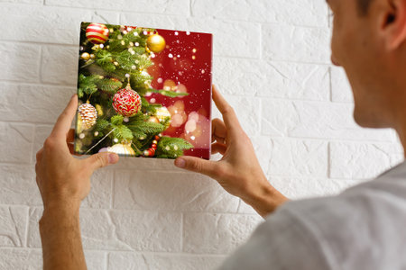 a man holding a photo canvas with a picture of christmasの写真素材