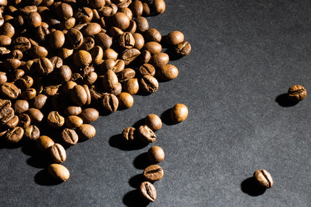 Several coffee beans isolated on black background with reflection. Culinary coffee background.