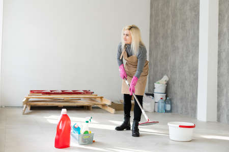 Professional janitor cleaning baseboard after renovationの写真素材