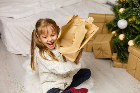 Happy little smiling girl with christmas gift box.の写真素材