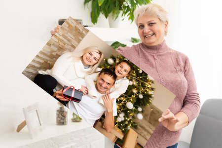 woman holding a photo canvas with a picture of christmasの写真素材