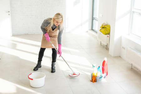 beautiful young cleaner cleaning officeの写真素材
