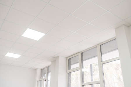 Acoustic ceiling with lighting and light channel window, Acoustic ceiling board texture Sound-proof material, Sound absorber, industry construction concept background black and white toneの写真素材