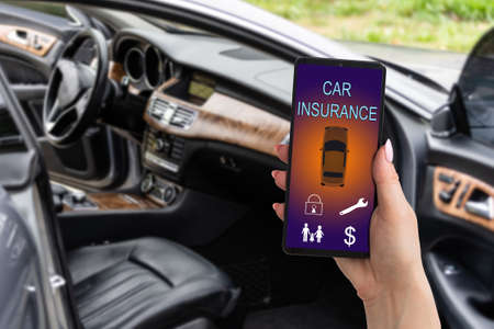 woman hand holding smartphone to use car insurance application online after his broken car. Insurance concept.の写真素材