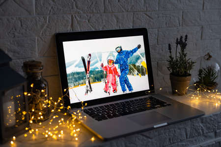 Image of open laptop family and christmas on wooden table in front of christmas tree backgroundの写真素材