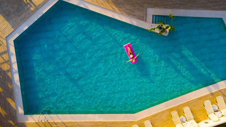 Young pretty woman with perfect body lying on air mattressの写真素材