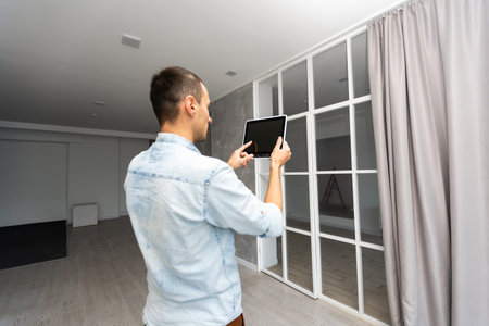 Smart Home: Man Controlling Blinds With His tabletの写真素材