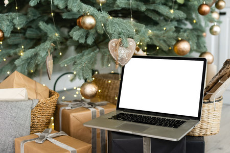 Laptop. Christmas tree and gifts on background