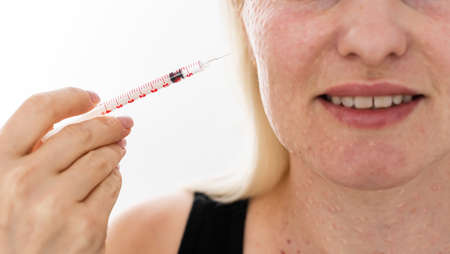 Real skin Biorevitalization on white background. Traces of biorevitalization injections on woman face. Biorevitalization needle marks Beauty treatment, real papules after hyaluronic injection.の写真素材