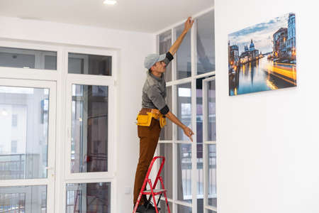 young fixer doing plasterboard partitioningの写真素材
