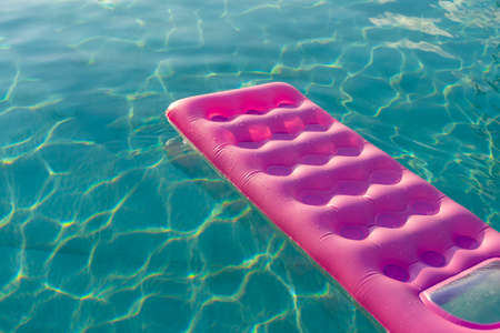 pink mattress in the swimming pool sunny dayの写真素材