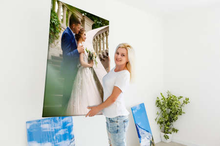 woman holding photo canvas on the background of a interiorの写真素材