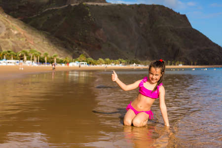 Adorable happy smiling little girl on beach vacationの写真素材