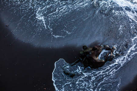 Black sand volcanic beach and view of Anaga mountains on northern coast in fishing village of Taganana, Tenerife island, Spainの写真素材