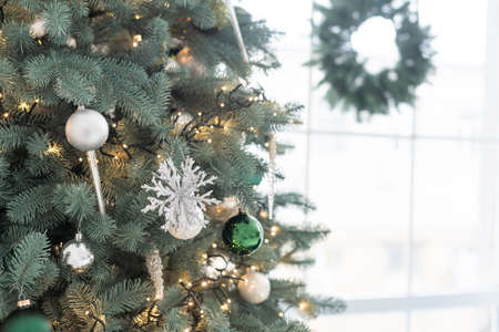 Christmas toys on a fir-tree close up with interior background of a luxury hotel apartmentの写真素材