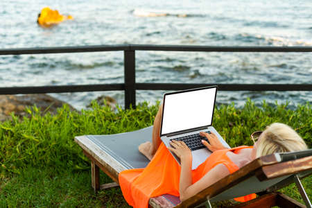 Beautiful Business Woman Working Online On Laptop Computer While Lying On Beach Lounger. Freelancer Girl Relaxing And Using Notebook Internet Work. Communication Technology.の写真素材