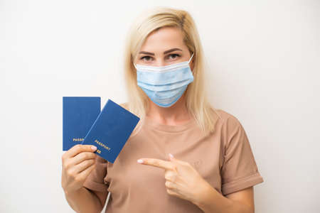 masked woman holding passportの写真素材