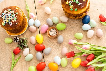 Easter cake and colorful eggs and flowers on the foreground