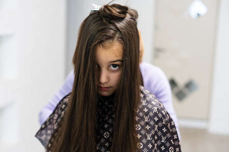 Little girl getting her new haircut in a barbershopの写真素材