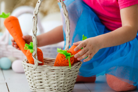 Getting ready to Easter. Lovely little girl holding an Easter egg and smiling with decoration in the...