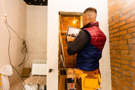 building, renovation, technology and people concept - close up of builder or workman hands with tablet pc computer.の写真素材