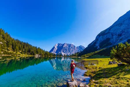 woman enjoying beauty of nature looking at mountain. Adventure travel, Europe. Woman stands on background with Alps.の写真素材