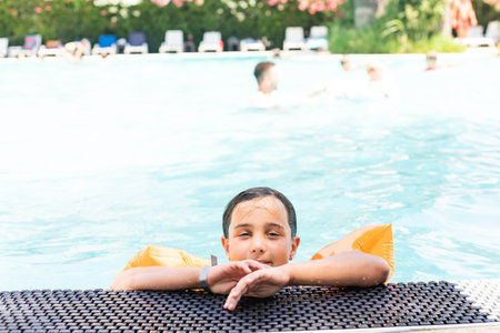 Beautiful little girl sunning at the poolの写真素材