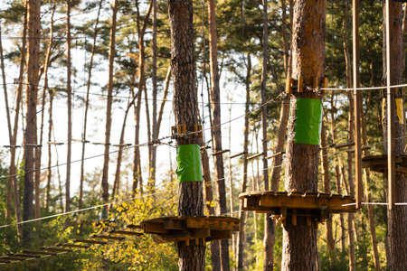 adventure climbing high wire park - people on course in mountain helmet and safety equipmentの写真素材