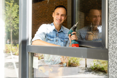 Construction worker installing window in house