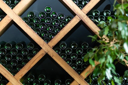Resting wine bottles stacked on wooden racks in cellar