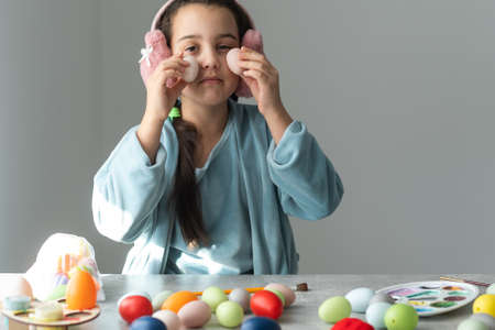 Little girl with Easter eggs indoorsの写真素材