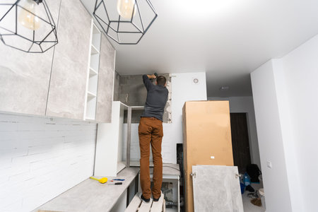 Worker installing new countertop in modern kitchen