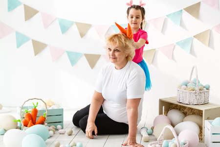 Easter concept. Happy llittle girl and grandmother with Easter eggsの写真素材