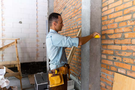 Smiling Builder repairman worker in dirty workwear at construction site.の写真素材