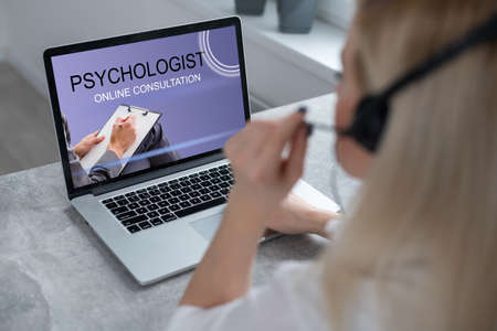 Freelancer, distant working, elearning concept. Young smiling pretty woman worker sitting and looking at laptop screen during videocall, online lecture. Distant learning, connectionの写真素材