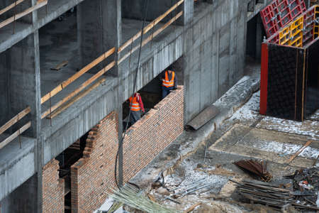 aerial top view of city construction site. tower cranes for building of new apartments under snow in winterの写真素材