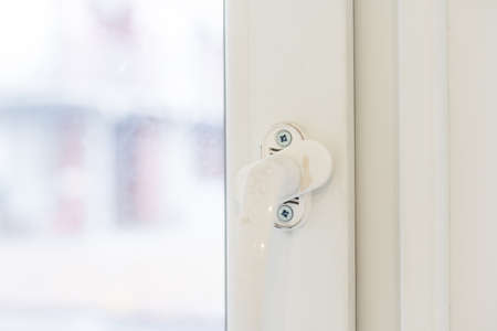 The handle of the new plastic door. White front door in a house under constructionの写真素材