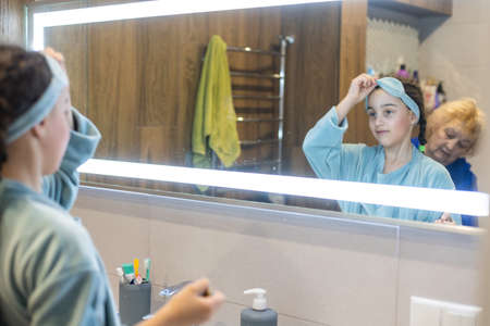 Grandma combs her granddaughters hair carefullyの写真素材