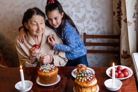 senior woman with easter eggs and Easter cakeの写真素材