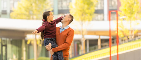 Happy father and daughter walking together in park on an autumns dayの写真素材