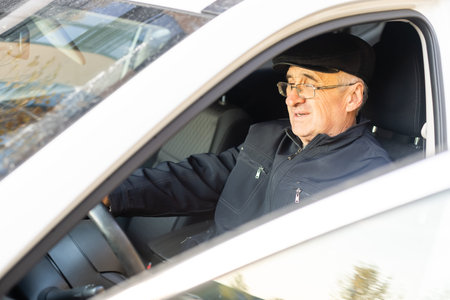 Smiling happy elderly man in the new car