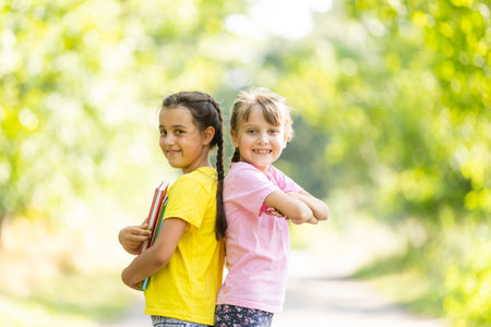 Two happy girls walking and talking each other in a campus