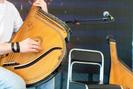 A man plays a traditional Ukrainian instrument at home. The musician plays the bandura.の写真素材