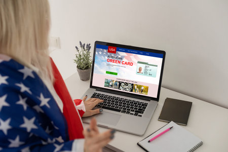 Green card in a search engine on the computer. laptop and american flag