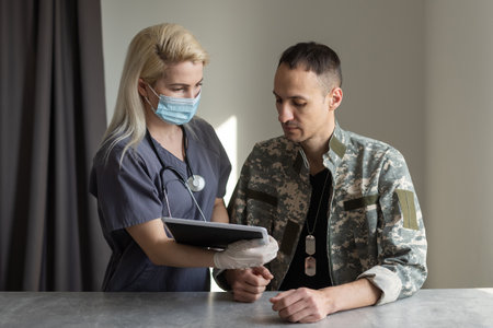 medical worker with military officer patient in hospitalの写真素材