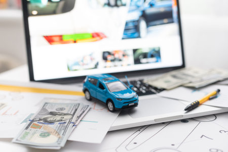 blue toy car with money and car key on wooden table.