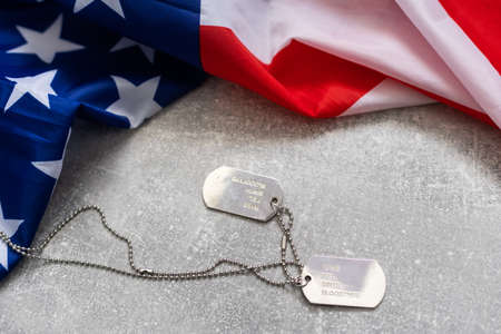 America United States flag and chain dog tags, military symbolizing, studio shot on concrete board background, US Veterans or Independence day conceptの写真素材