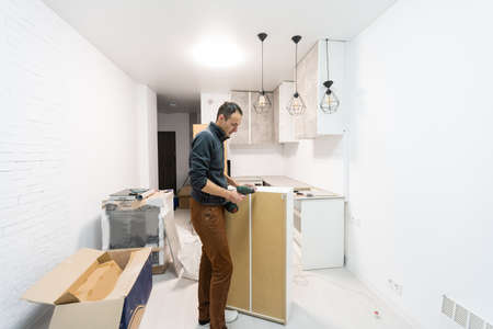 Worker installing new countertop in modern kitchenの写真素材