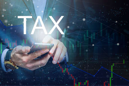 Businessman With Mobile Phone Opens Hologram HUD Interface and Touches Word - TAX.の写真素材