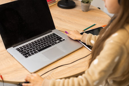 Connection is good i can here you. Little kid girl sit comfort cozy table desk study remote use laptop online teacher communication chatting have headset in house indoorsの写真素材